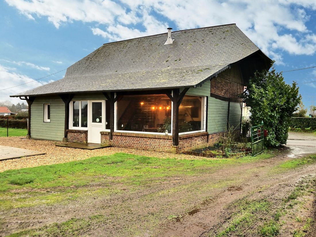 Maison normande à bardage bois sous un toit d’ardoise débordant